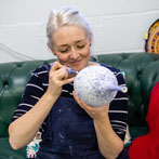 Rhian Malin decorating a mandala bottle in her workshop 2019